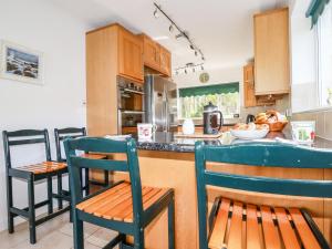 a kitchen with chairs and a counter with a counter top at Trevow in Camborne