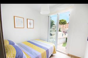 a white bedroom with a bed and a window at Modern 2 bedroom apartment in Benalmádena Costa in Benalmádena