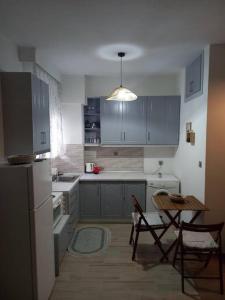a kitchen with blue cabinets and a table and chairs at VagelisHome in Komotini +4 photos