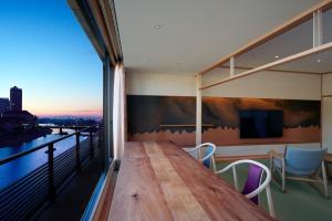 Habitación con balcón con mesa y sillas. en Hotel Wakamizu en Takarazuka