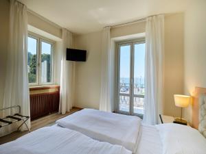 1 dormitorio con 2 camas y ventana grande en Hotel San Marco en Garda