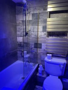 La salle de bains est pourvue d'une baignoire, de toilettes et d'une douche. dans l'établissement Glenville House - Adults Only - Incl FREE off-site health club with swimming pool, hot tub, sauna & steam room, à Windermere