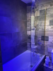 een badkamer met een bad en een glazen douche bij Glenville House - Adults Only - Incl FREE off-site health club with swimming pool, hot tub, sauna & steam room in Windermere