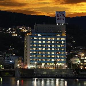 a large building with a sign on top of it at Atami Tamanoyu Hotel in Atami