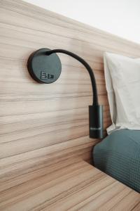 a black lamp on a wall next to a bed at Casa Velha Apartments - Adults friendly in Albufeira
