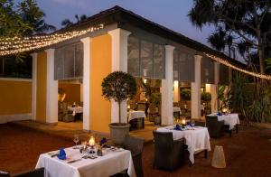 a restaurant with white tables and chairs and lights at The Villa Bentota by KK Collection in Bentota