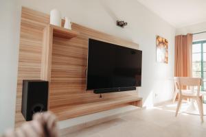 a living room with a flat screen tv on a wall at Casa Velha Apartments - Adults friendly in Albufeira