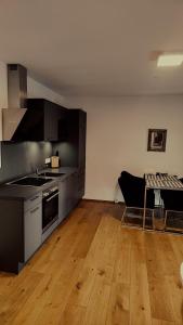 uma cozinha com electrodomésticos em aço inoxidável e piso em madeira em SPA RESIDENZ NEUSIEDL APPARTMENTS em Neusiedl am See