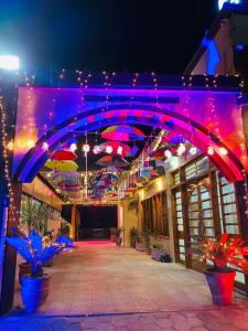 ein Gebäude mit lila Leuchten und Sonnenschirmen in der Unterkunft Indus Lodges Gilgit in Gilgit