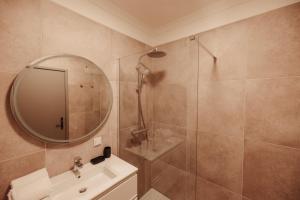 a bathroom with a shower and a sink and a mirror at Casa Velha Apartments - Adults friendly in Albufeira