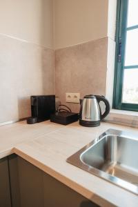 a kitchen counter with a tea kettle and a sink at Casa Velha Apartments - Adults friendly in Albufeira