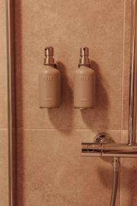 two bottles ofodorizers sit on the wall of a shower at Casa Velha Apartments - Adults friendly in Albufeira