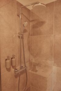 a shower with a glass door and a shower head at Casa Velha Apartments - Adults friendly in Albufeira