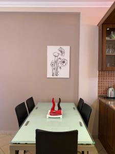 a dining room with a green table with chairs at Cloud8 Apt with Castle View, 7km from the Beach in Lezhë