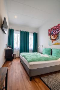 1 dormitorio con 1 cama con sábanas verdes y cortinas azules en Löwen Unterkunft Langenhagen, en Hannover