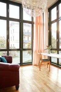 uma sala de estar com uma mesa e janelas grandes em Cityloft - im Zentrum, inkl Parkplatz, Netflix, 3-Raum em Leipzig