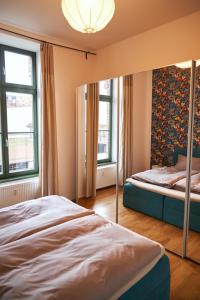 1 dormitorio con 2 camas y 2 ventanas en Cityloft - im Zentrum, inkl Parkplatz, Netflix, 3-Raum, en Leipzig