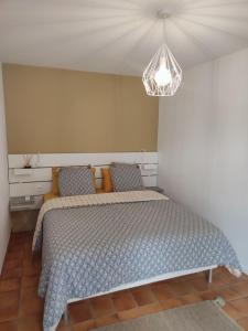 Les Gîtes De La Caneda في سارلا لا كانيدا: غرفة نوم مع سرير وأثاث خفيف