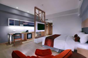 Schlafzimmer mit einem Bett und einem Schreibtisch mit einem TV in der Unterkunft Neo+ Penang in George Town