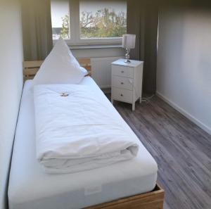 マールブルク・アン・デア・ラーンにあるFerienwohnung in Marburg/Wehrdaのベッドルーム1室(白いシーツ付きのベッド1台、窓付)