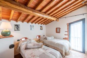 two beds in a room with wooden ceilings at Agriturismo Podere Luisa in Montevarchi