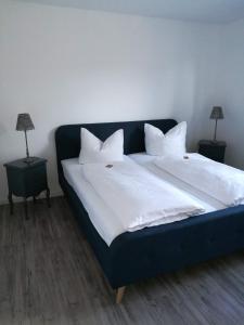 a blue bed with white sheets and pillows on it at Ferienwohnung in Marburg/Wehrda in Marburg an der Lahn