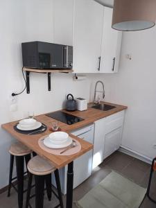 małą kuchnię ze stołem i kuchenką mikrofalową w obiekcie Tiny81 cozy city break appartment w mieście Clichy
