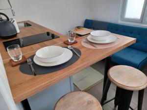 drewniany stół z płytami i okularami w obiekcie Tiny81 cozy city break appartment w mieście Clichy +5 zdjęć