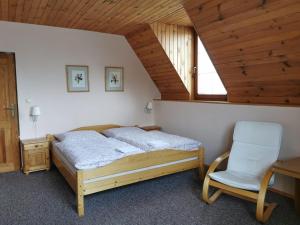 een slaapkamer met een bed en een stoel bij Privát Kováč in Vysoké Tatry
