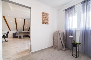 a living room with white walls and a large mirror at Villa Gabi in Pridraga