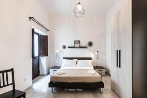 a bedroom with a bed in a white room at Pomillo Rooms in Noto