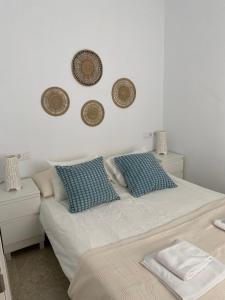 a bedroom with a bed with blue and white pillows at Conil Homes V Apartments in Conil de la Frontera