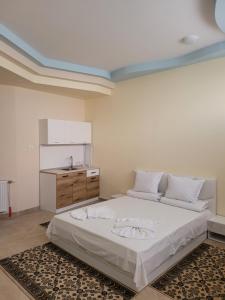 a bedroom with a large bed and a kitchen at Китанови- стаи за гости in Sliven