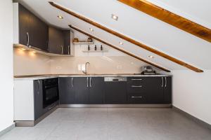 a kitchen with black cabinets and a staircase at Villa Gabi in Pridraga