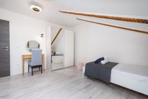 a bedroom with a bed and a desk and a chair at Villa Gabi in Pridraga