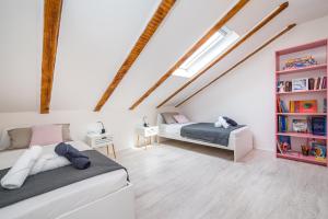 a attic bedroom with two beds and a book shelf at Villa Gabi in Pridraga