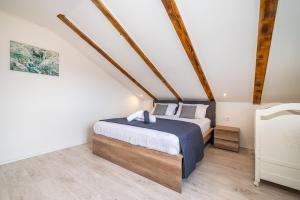 a bedroom with a king sized bed in a attic at Villa Gabi in Pridraga