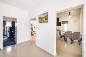 a dining room and living room with a table and chairs at Villa Gabi in Pridraga
