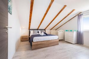 a bedroom with a king sized bed and wooden floors at Villa Gabi in Pridraga