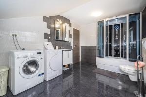 a bathroom with a washing machine and a sink at Villa Gabi in Pridraga