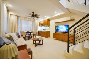 a living room with a couch and a tv at The Apartments at El Nido in El Nido