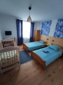 1 dormitorio con 2 camas y 1 cuna en Pawłówka B&B, en Szklarska Poręba