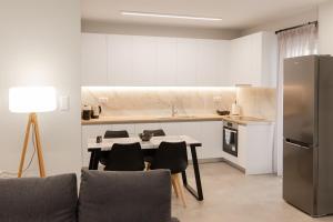 cocina con mesa, sillas y nevera en Athens Heart Luxury Flat en Athens