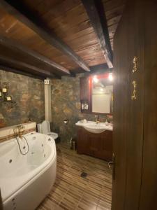 a bathroom with a bath tub and a sink at Blessings Chalet στον Παλαιό Άγιο Αθανάσιο με Τζάκι, Barbeque, μεγάλη αυλή και υπέροχη θέα in Palaios Agios Athanasios