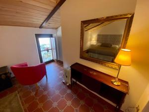 ein Schlafzimmer mit einem Spiegel und einem roten Stuhl in der Unterkunft Casa del Marqués in Fregenal de la Sierra