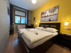 1 dormitorio con 1 cama grande y pared amarilla en Central Studios, en Praga