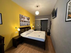 a bedroom with a bed and a yellow wall at Central Studios in Prague