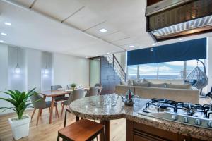 Il dispose d'une cuisine et d'un salon avec une cuisinière et un canapé. dans l'établissement Tayri - Duplex Luxe - 4 ou 5 PX, à Agadir