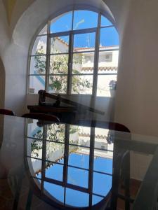 einen Glastisch in einem Zimmer mit einem großen Fenster in der Unterkunft Casa del Marqués in Fregenal de la Sierra