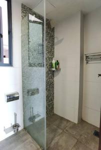 baño con ducha y puerta de cristal en Jeff and Ricky Homestay 39 @ Vivacity (Huge Unit) en Kampong Tabuan